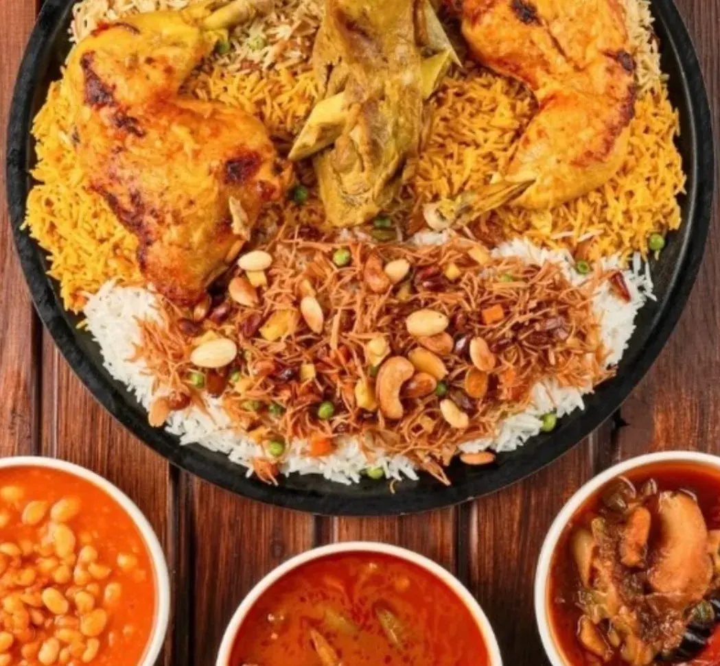 A vibrant Biryani dish by Biryani Addicts food truck with golden chicken, rice, nuts, and three side bowls.